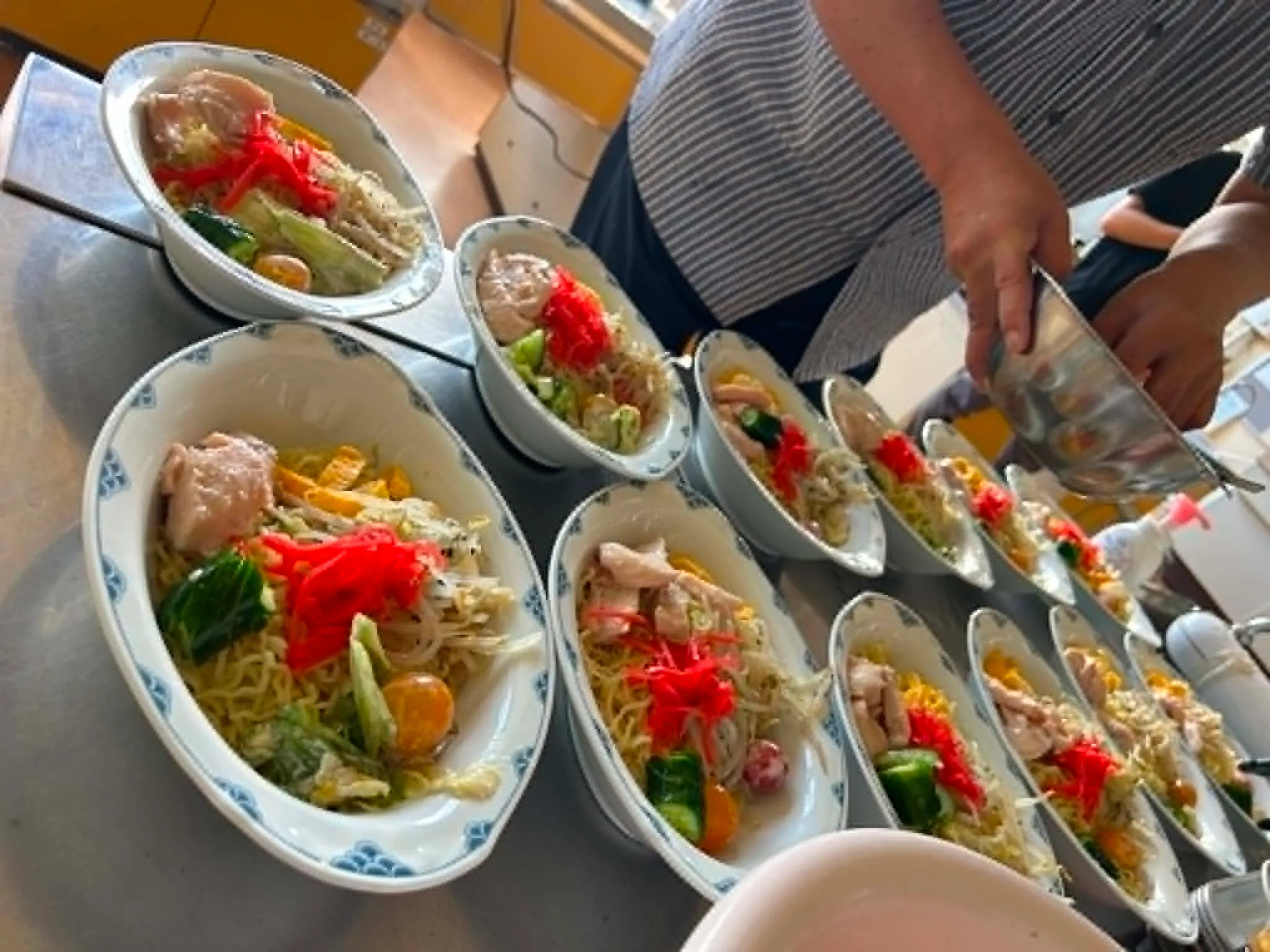 社長手作りの食事、彩り豊かな麺料理が並ぶ様子